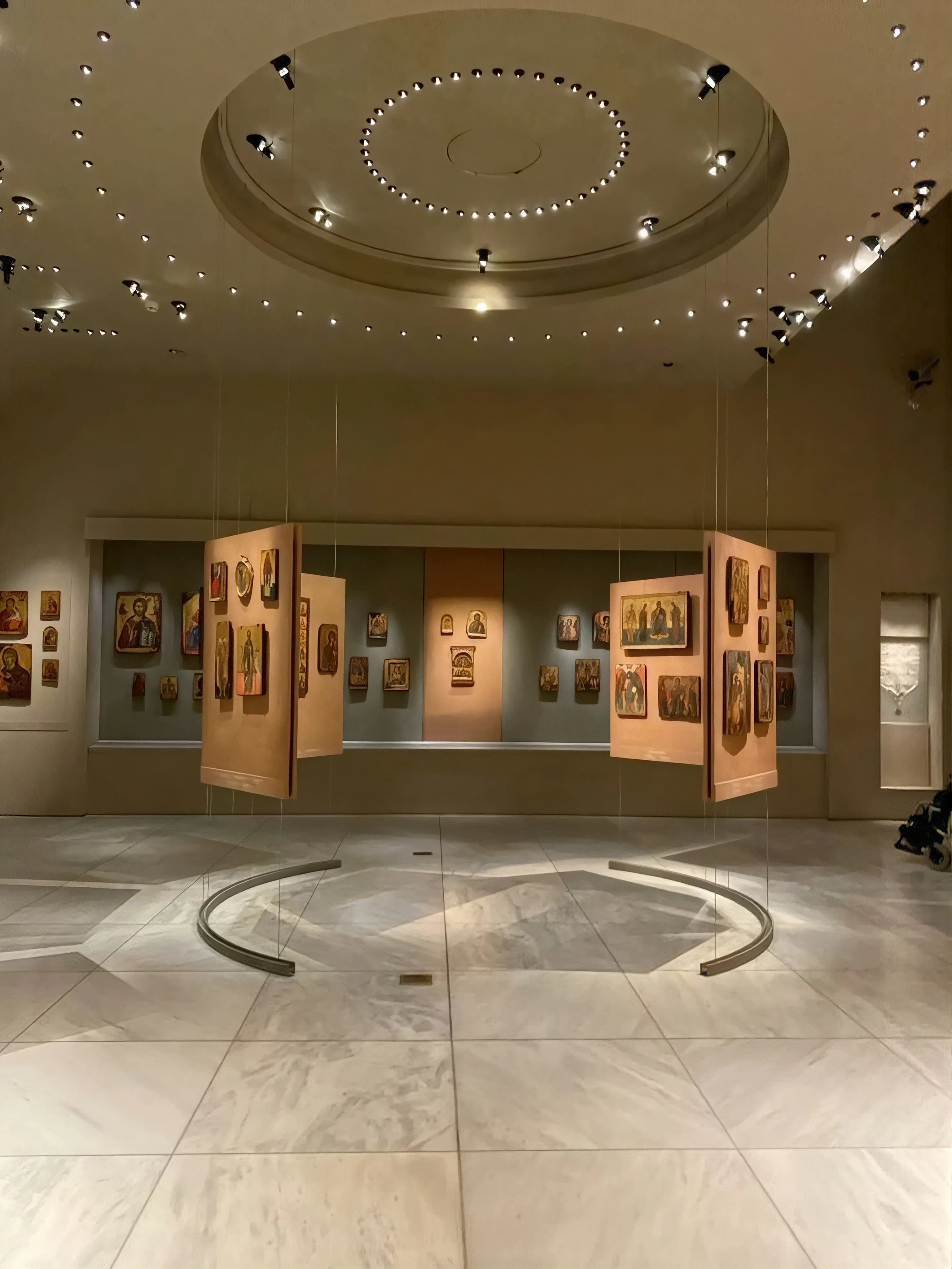 Framed paintings hung close together above a panelled dado