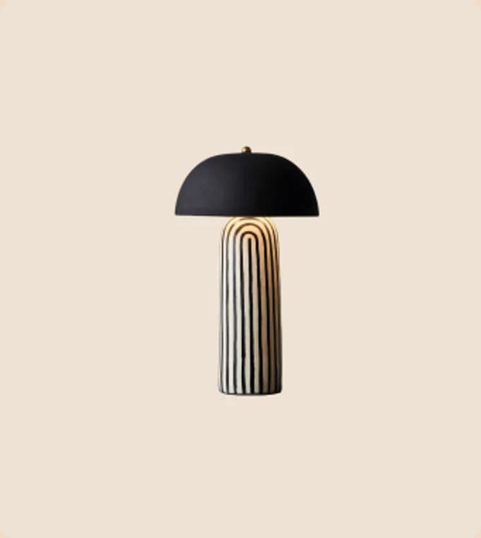 A black dome table lamp on a fluted brass base