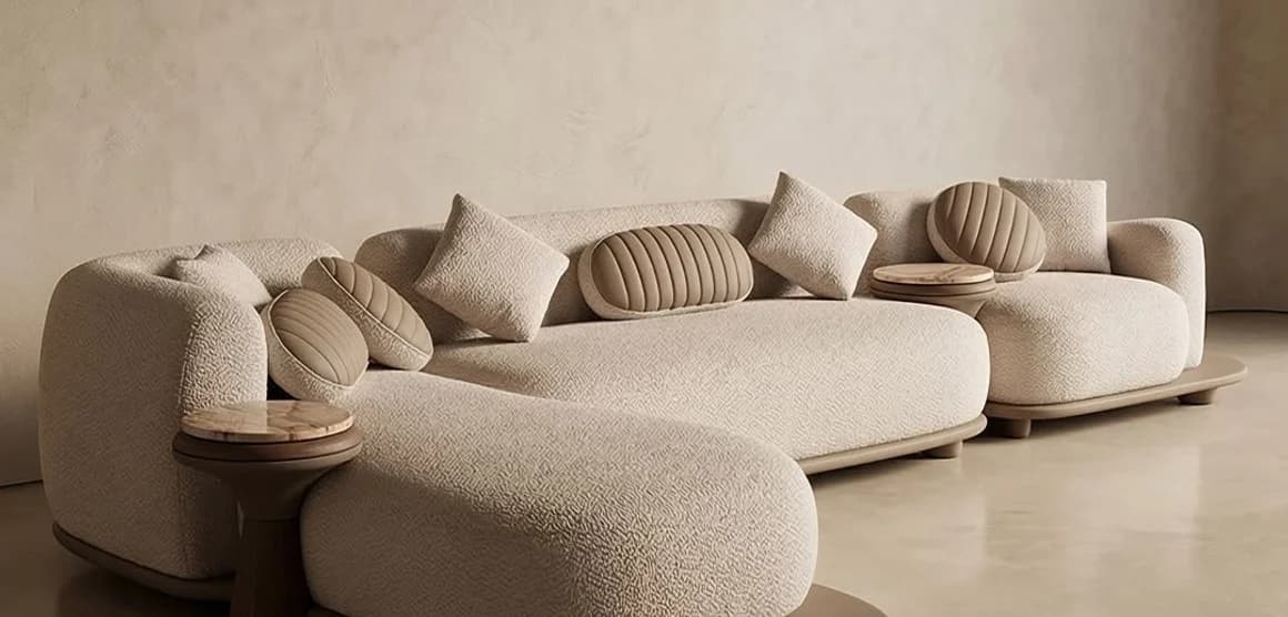 A cream curved sofa and ottoman in a plaster room