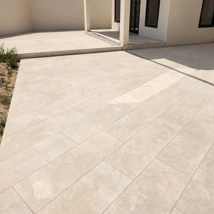A sealed stone patio running to a house wall