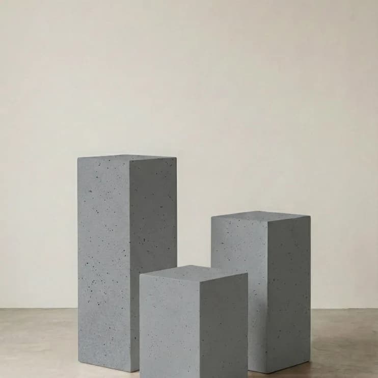 Three precast concrete blocks against a grey wall
