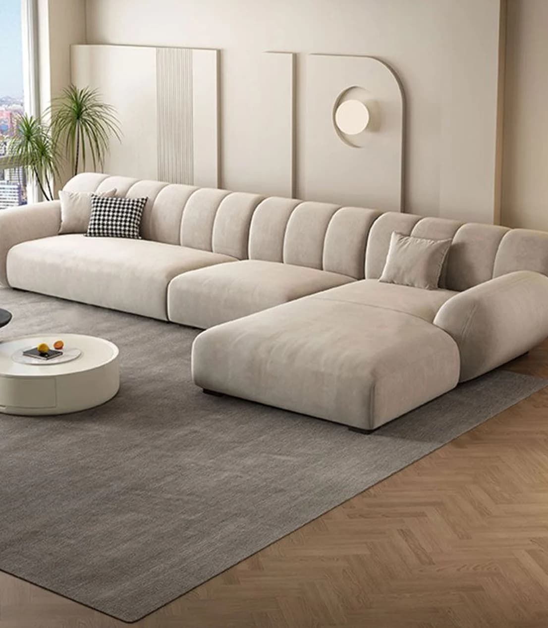 A cream sectional sofa on a pale rug over herringbone parquet