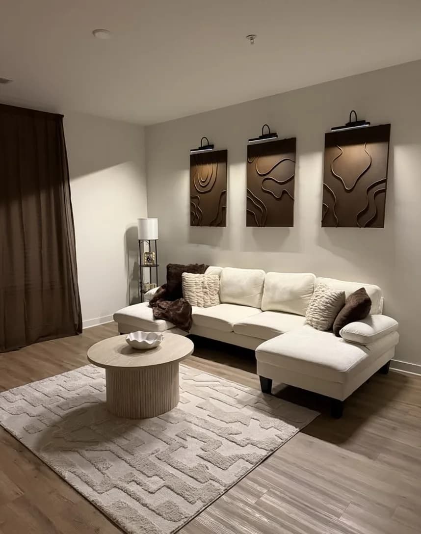 A cream sofa and round table in a curtained room
