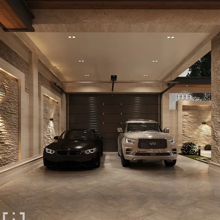 Two cars in a lit garage with a stone feature wall