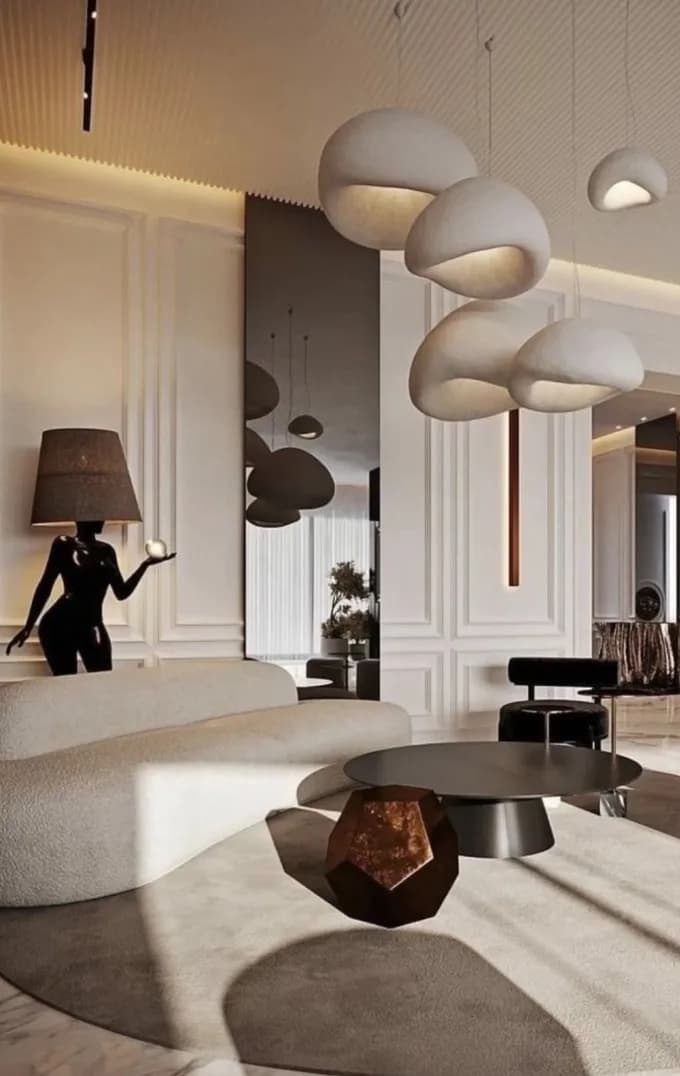 A sculptural lobby with a dark figure beside a round table
