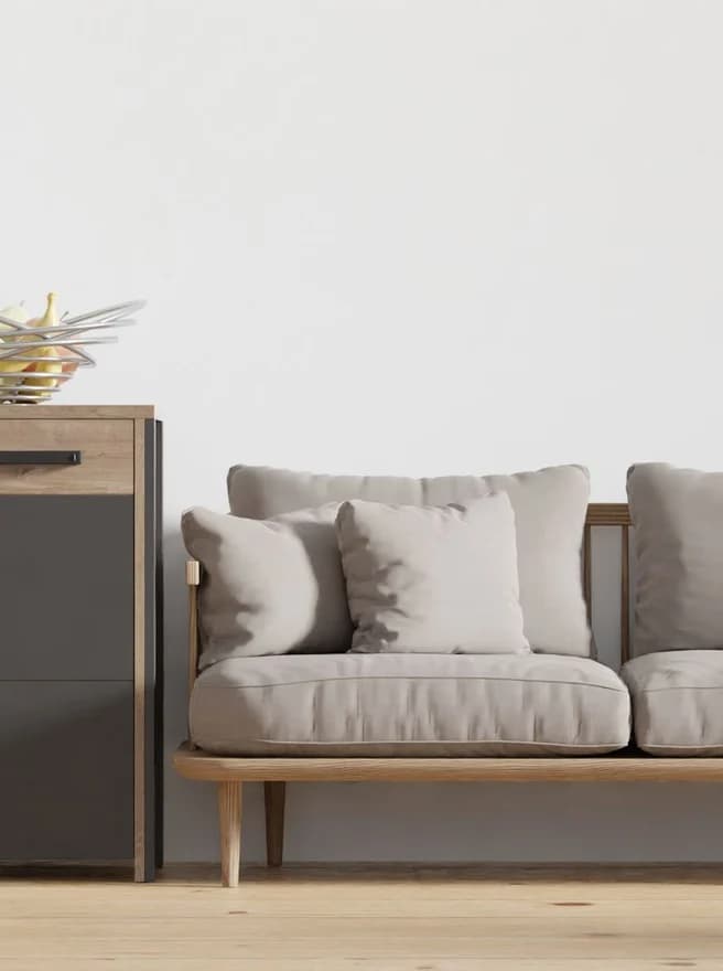 A pale two-seat sofa and sideboard against a white wall