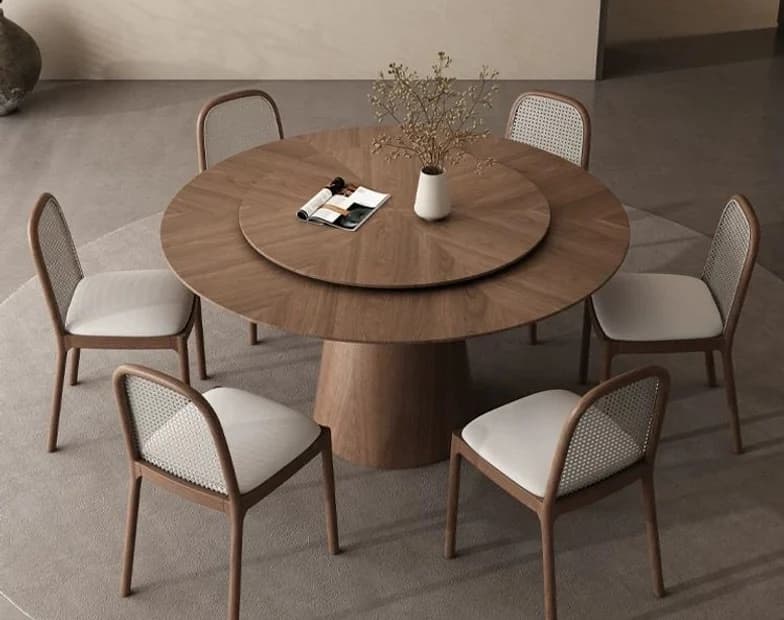 A round walnut dining table with five upholstered chairs