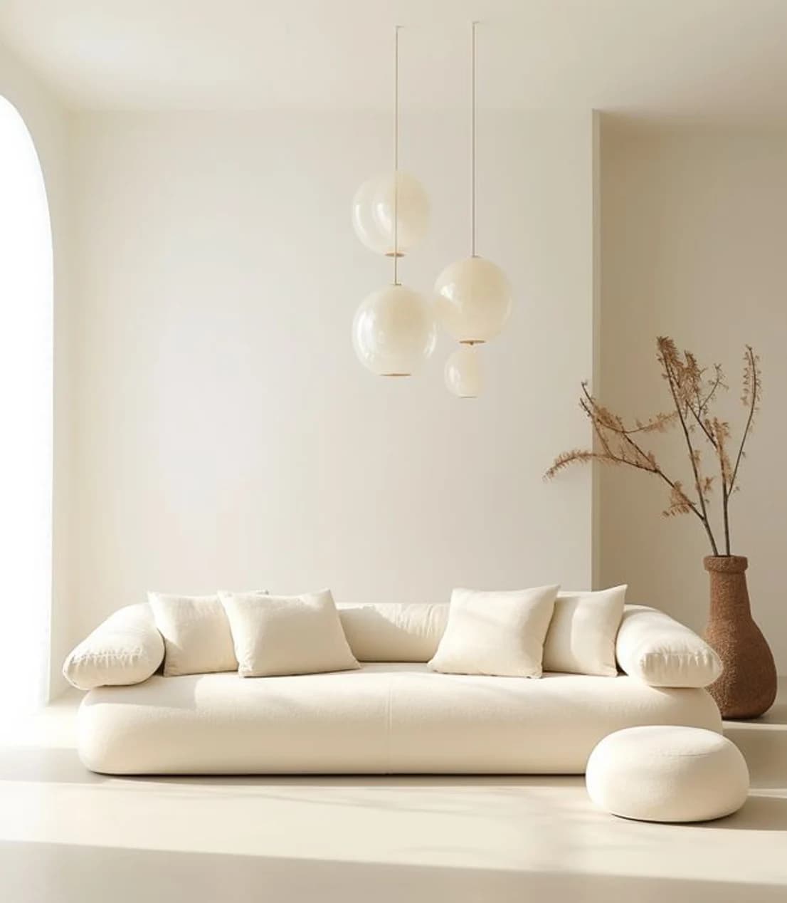 A cream daybed under a cluster of paper globe pendants