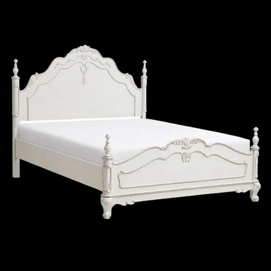 A carved white wooden bed frame with a shaped headboard