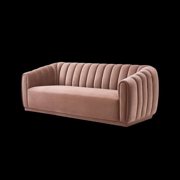 A channel-tufted sofa in dusty rose velvet