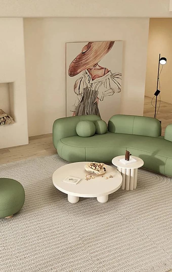 A sage sectional around a plaster coffee table