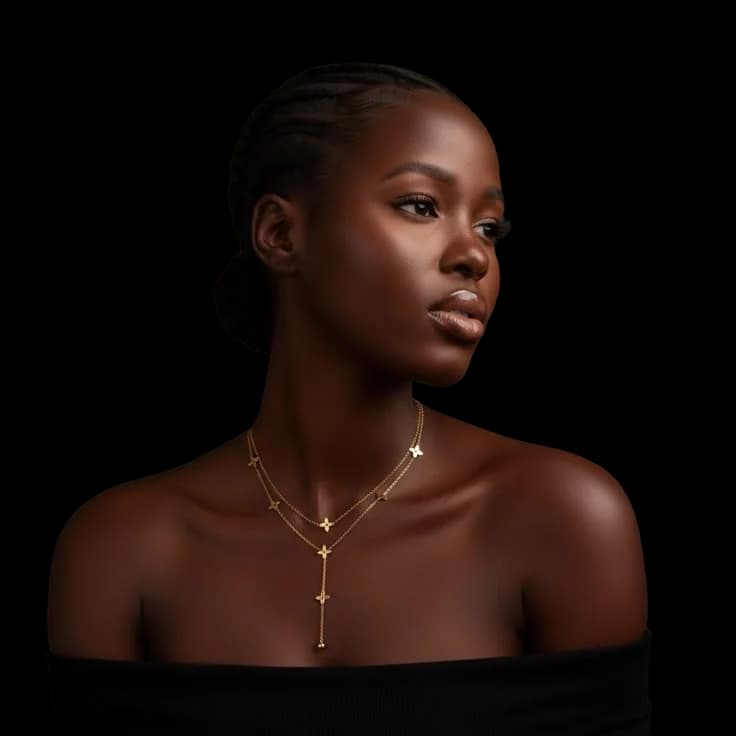 Layered fine gold chains on a bare shoulder