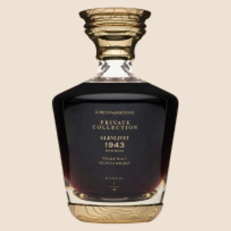 A squat dark decanter with a ribbed gold stopper