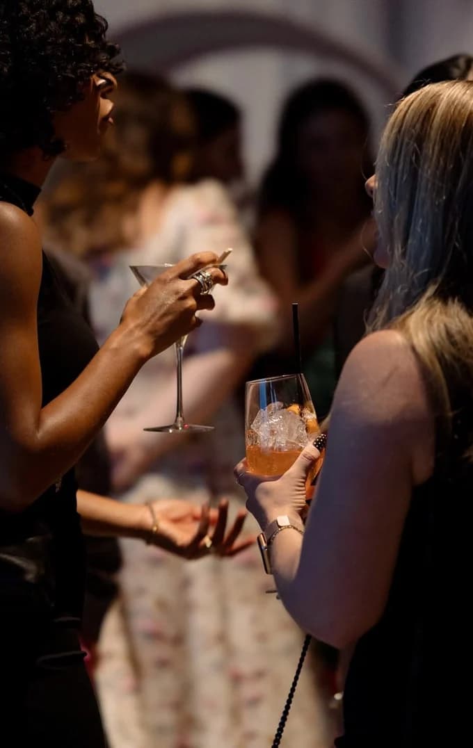 Guests with cocktails at a low-lit party