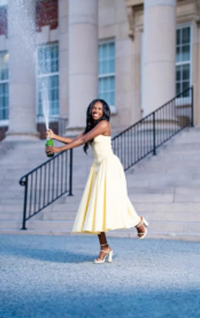 A guest in a white dress raising a glass on a stone stair