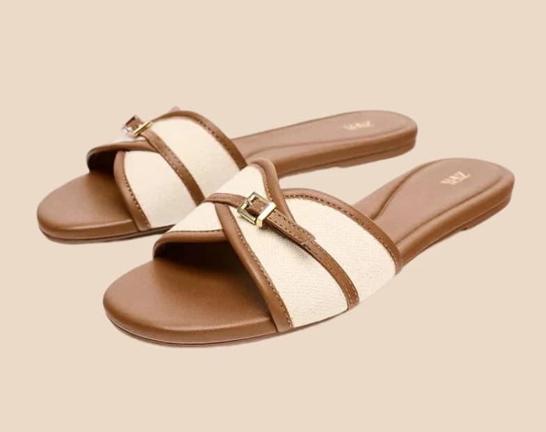 Tan leather slides with crossed canvas straps and a gold buckle