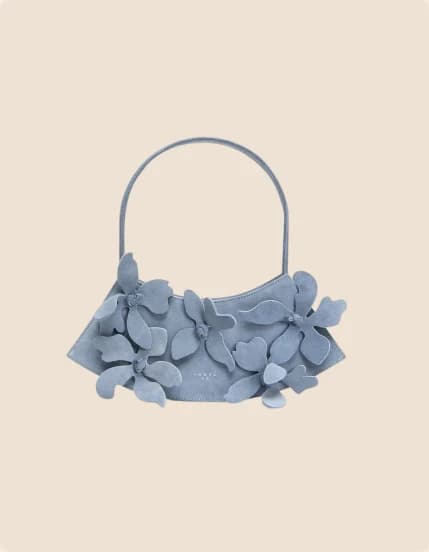 A pale blue bag covered in overlapping leather petals