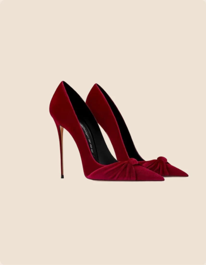 A burgundy velvet stiletto pump with a knotted bow at the toe