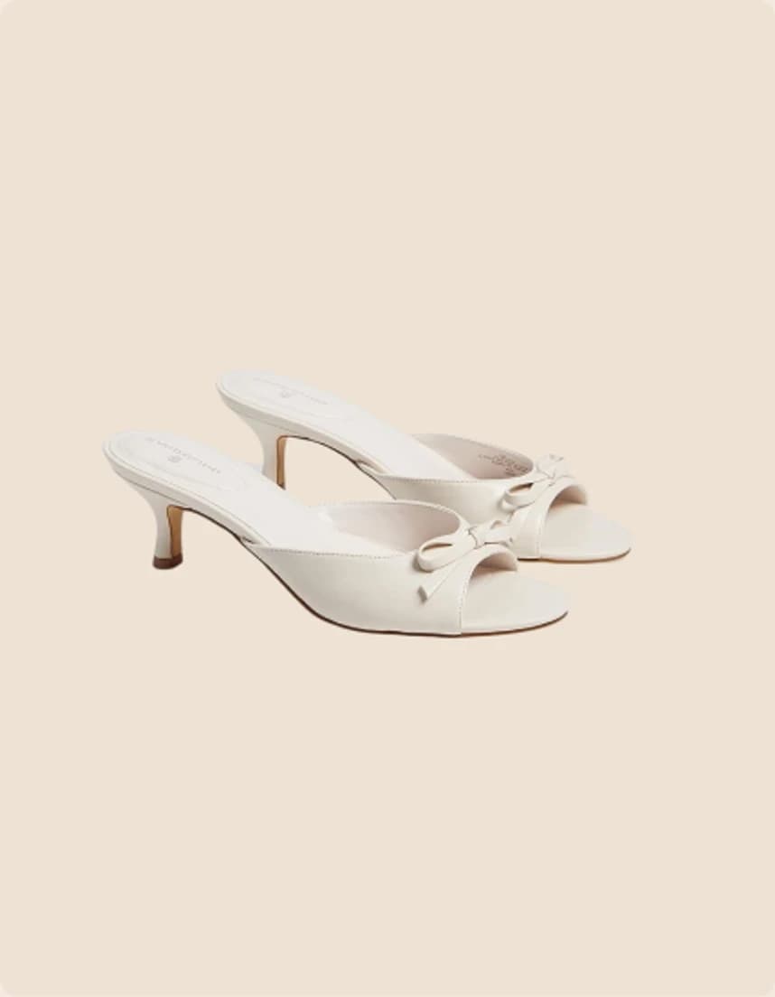 A white leather mule with a knotted band and kitten heel