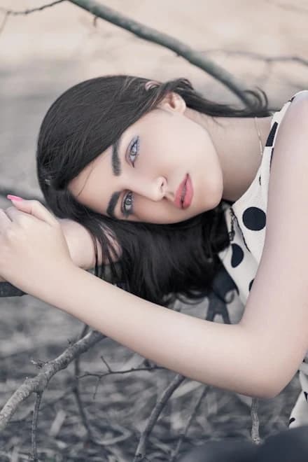 A portrait of the artist Ines Haddad resting against a pale ground